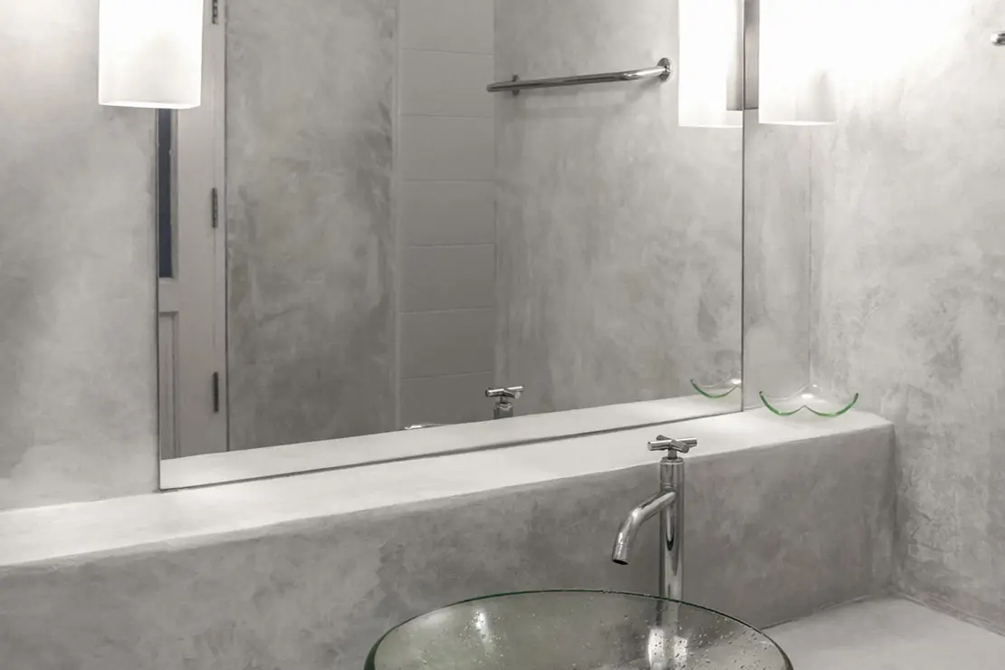 Aseo con muros y superficie de trabajo de microcemento en tono gris. Aseo con muros y superficie de trabajo de microcemento en tono gris.